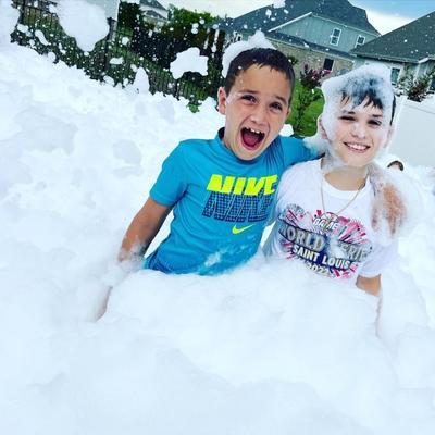 Two young boys smiling and playing in foam bubbles during a foam party in Washington DC, Maryland, Virginia.