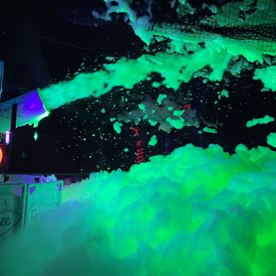 A vibrant glow-in-the-dark foam party setup in Washington DC, featuring colorful glowing foam illuminated by black lights, creating an exciting and fun atmosphere.